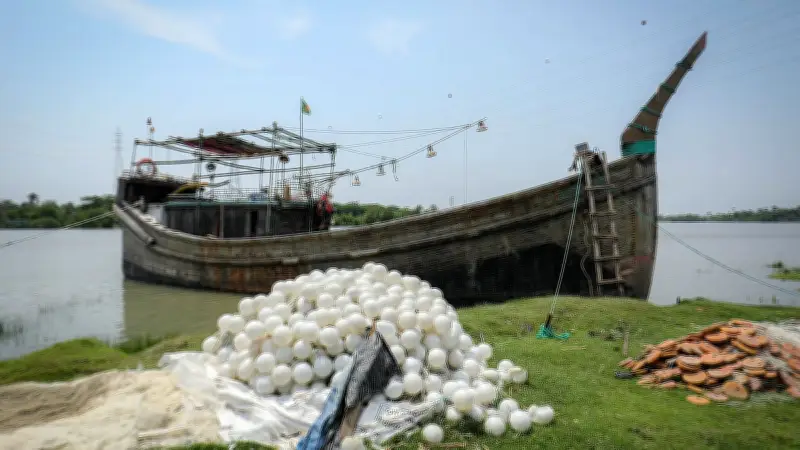 মাছ ধরার ট্রলার মেরামত ও জাল বুননে ব্যস্ত জেলেরা